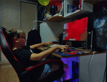 a boy sits at a desk in front of a computer monitor that says ' nintendo ' on it