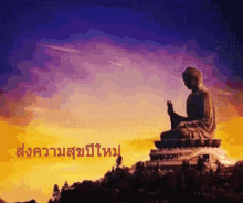 a statue of a buddha sitting on top of a hill with a sunset in the background and a foreign language written below