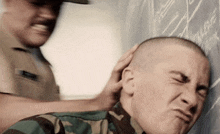 a man in a military uniform is being slapped on the head by another man