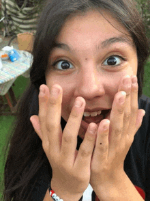 a girl is making a funny face with her hands