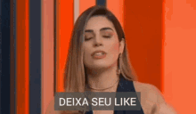 a woman with her eyes closed is standing in front of a sign that says deixa seu like