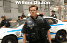 a man in a police uniform is standing in front of a white police car