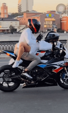 a man is riding a motorcycle with a woman sitting on his lap