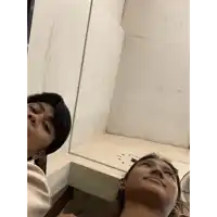 a man and a woman are looking up at their reflections in a mirror