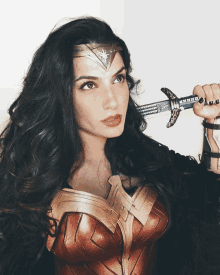 a woman dressed as wonder woman holds a sword