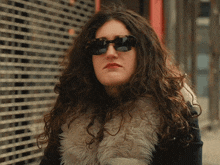 a woman wearing sunglasses and a fur coat