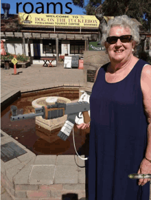 an older woman holding a gun in front of a sign that says roams