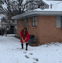 a woman in a red dress is standing in the snow in front of a brick house with the words snowball fight written above her