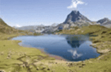 a blurred image of a lake surrounded by mountains with a mountain in the background .