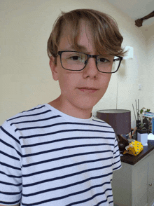 a boy wearing glasses and a striped shirt