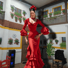 a woman in a red dress is dancing in a room