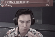 a man wearing headphones with the words firefly 's biggest fan gang on the screen