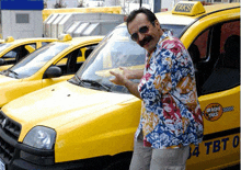 a man standing in front of a taxi that says taksi on it