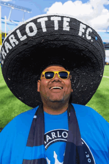 a man wearing sunglasses and a sombrero with charlotte fc written on it