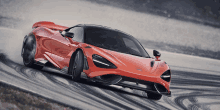 a red mclaren supercar is driving down a track