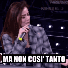 a woman is singing into a microphone with the words ma non cos ' tanto written below her