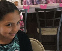 a girl sits in front of a table with pink hearts on it and a sign that says love