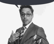 a man wearing glasses and a suit has a speech bubble above his head