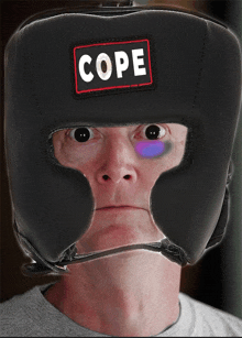 a man wearing a boxing helmet that says cope