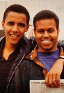 two young men are posing for a picture and one of them is holding a newspaper that says gorbachev asks