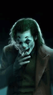 the joker from the movie the joker is smoking a cigarette in the dark .