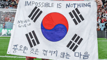 a soccer player holds up a flag that says impossible is nothing