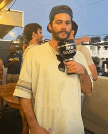 a man with a beard is holding a mug that says big daddy