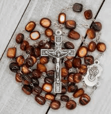 a rosary with wooden beads and a cross on a wooden table .