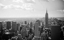 a black and white photo of new york city with the empire state building in the foreground