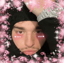 a man wearing a black beanie and a watch is surrounded by pink hearts