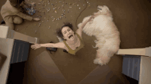 a woman laying on the floor with a dog laying on the floor