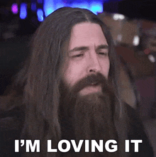 a man with long hair and a beard saying i 'm loving it