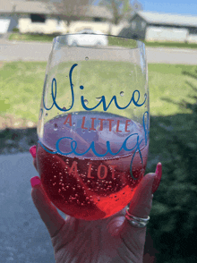 a glass that says wine a little and a lot on it