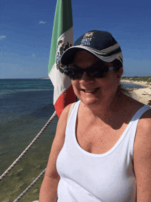 a woman wearing a white tank top and a hat that says ' pacific coast ' on it