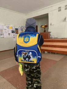 a boy wearing a backpack that says ukraine