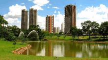 a lake with a fountain in the foreground and a city in the background