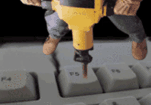 a yellow drill is being used to drill the f5 key on a computer keyboard