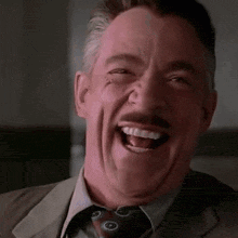 a man in a suit and tie is making a funny face .