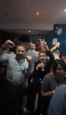 a group of people dancing in a dark room with a red light on the ceiling