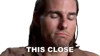 a close up of a man 's face with the words " this close " above him