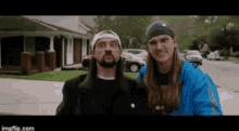 a man and a woman are standing next to each other on the sidewalk in front of a house .