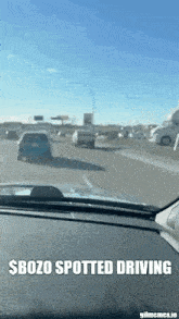 a car is driving down a highway with a sign that says $ bozo spotted driving on the dashboard .