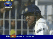 a cricket player wearing a helmet is being shown on a television screen