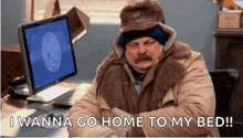 a man sitting in front of a computer with the words " i wanna go home to my bed "