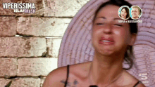 a woman is crying in front of a brick wall with the words viperissima island trash