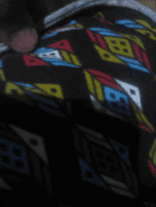 a close up of a blanket with a geometric pattern and the letter b on it