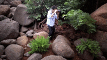 a man taking a picture with a camera surrounded by rocks