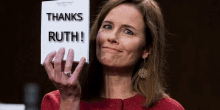 a woman in a red jacket is holding a piece of paper that says thanks ruth