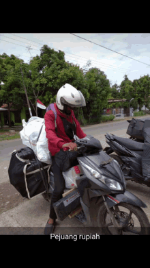 a man is riding a motorcycle with the words pejuang rupiah written below him