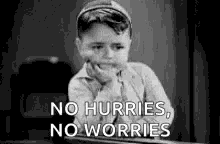 a black and white photo of a young boy sitting at a desk with his hand on his chin and a quote .